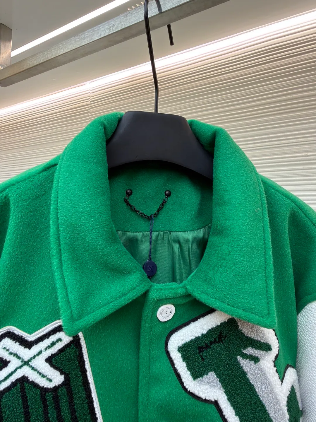 LOUIS VUITTON Loose long-sleeved baseball jersey with monogram pattern ●Original version: Purchased and developed for 29999 ●Item number: 1682254-C10 ●Fabric: cotton fabric ●Technology: embroidery production ●Color: green ●Version: fitted version ●Weight: about 1145 grams ●Size: 46-48-50-52 ●Description: The main body of this Louis Vuitton baseball jacket is made of high-count wool blended fabric. It has been processed by raising and carding processes. The fabric has a full velvety feel and is crisp and stylish. The green base color is made of worsted dyeing process. The color is pure and not easy to fade. The sleeves are spliced ​​with custom pebbled artificial leather, which has been embossed and softened. The texture is natural, flexible to the touch, and is scratch-resistant and wear-resistant. The letters and patterns decorated on the body are made of terry embroidery + appliqué embroidery composite technology. The terry embroidery coils are fluffy and three-dimensional, and the edges of the appliqué embroidery are overlocked to ensure accurate pattern splicing. The handwritten text is made using flat embroidery technology, with fine stitches and clear fonts. The placket is made of custom-made mother-of-pearl buttons, which are hand-polished and polished to have a warm luster; the ribbed neckline and hem are made of spandex blended material, which has good resilience and is not easy to loosen. The overall design uses three-dimensional tailoring and hand-sewing techniques to integrate a variety of materials and embroidery techniques to fully demonstrate the essence of haute couture garments. The overall wiring is straight and delicate, the fabric is comfortable and soft, and the color is consistent without color difference. It can be matched with the same style to create a fashionable look and control various occasions. Customized accessories, complete with three standards, same style for men and women!